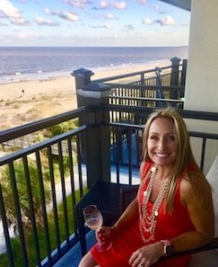 Karin, Coastal Endodontics' special projects officer, standing on a balcony and smiling
